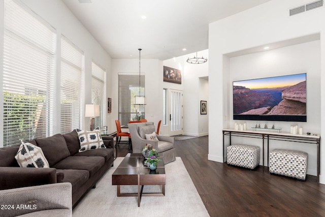 living room featuring dark wood-type flooring and a notable chandelier