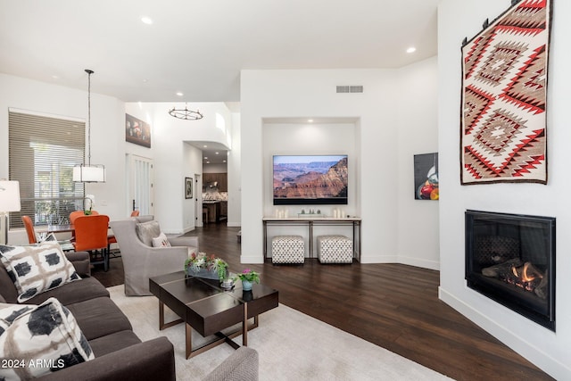 living room with a chandelier and dark wood-type flooring