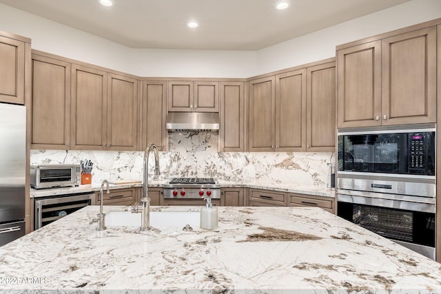 kitchen featuring appliances with stainless steel finishes, light stone counters, backsplash, and wine cooler