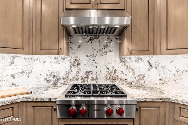 kitchen featuring decorative backsplash, extractor fan, stainless steel gas stovetop, and light stone counters