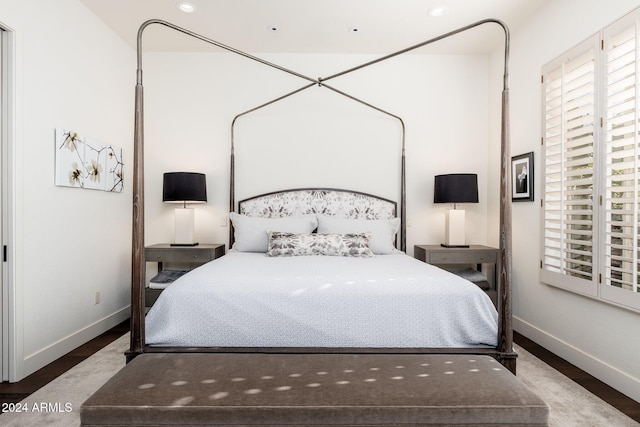 bedroom featuring dark hardwood / wood-style flooring and multiple windows