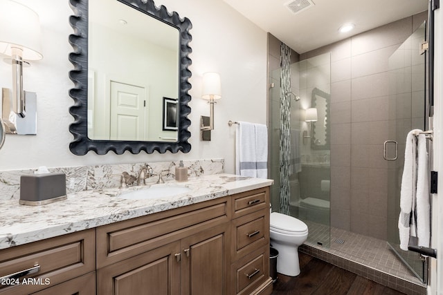 bathroom featuring hardwood / wood-style floors, vanity, toilet, and walk in shower