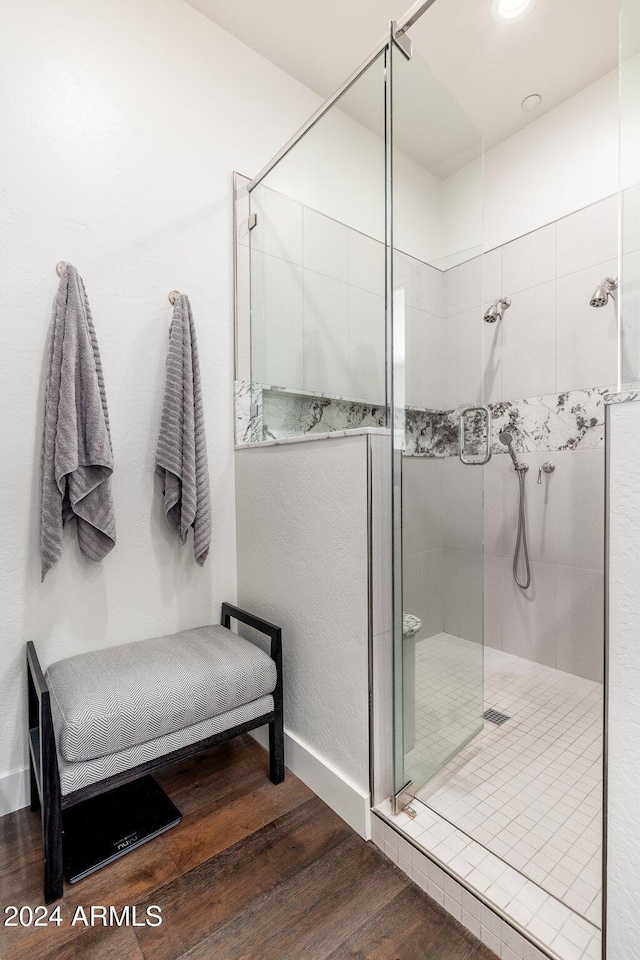 bathroom with hardwood / wood-style floors and an enclosed shower