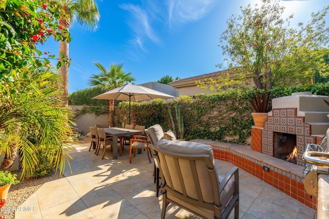 view of patio with exterior fireplace