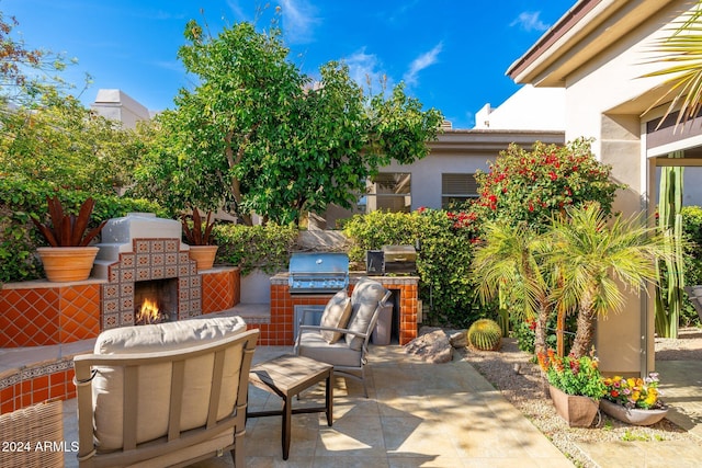 view of patio with a grill, exterior kitchen, and an outdoor fireplace