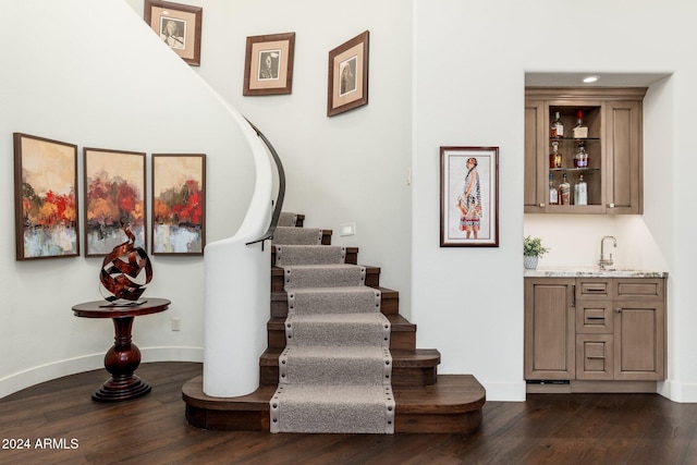 staircase featuring hardwood / wood-style flooring and wet bar