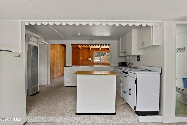 kitchen with white cabinets, sink, butcher block countertops, and light colored carpet