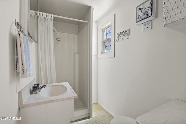 bathroom featuring baseboards, a stall shower, and a sink