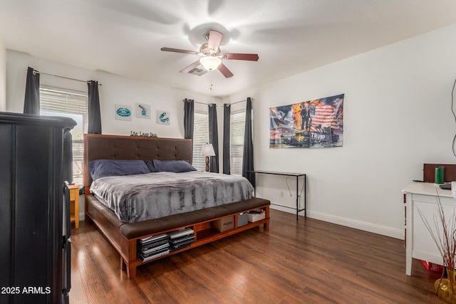 bedroom featuring multiple windows, dark hardwood / wood-style floors, and ceiling fan