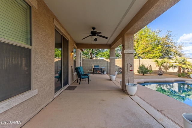 view of patio featuring a fenced in pool and ceiling fan