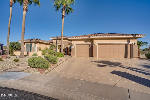 mediterranean / spanish house featuring concrete driveway, a tile roof, an attached garage, and stucco siding