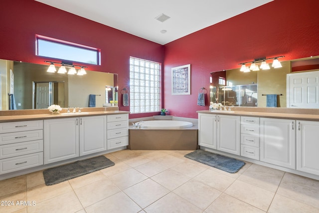 bathroom with tile patterned flooring, vanity, and a bathing tub