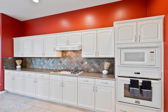 kitchen featuring white cabinets, white appliances, light tile patterned floors, and decorative backsplash