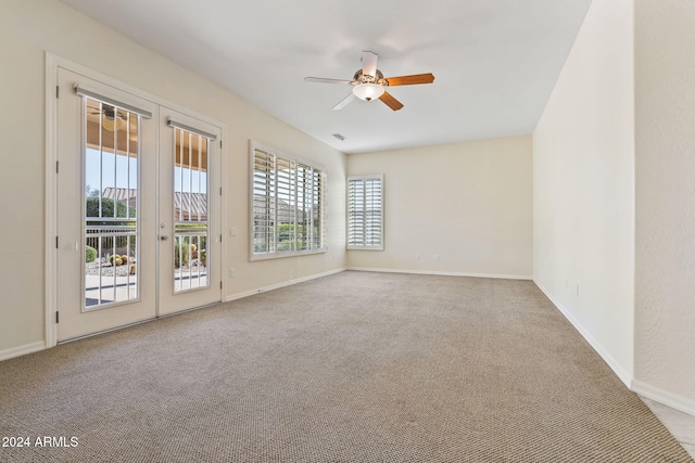 spare room with carpet, visible vents, baseboards, and ceiling fan