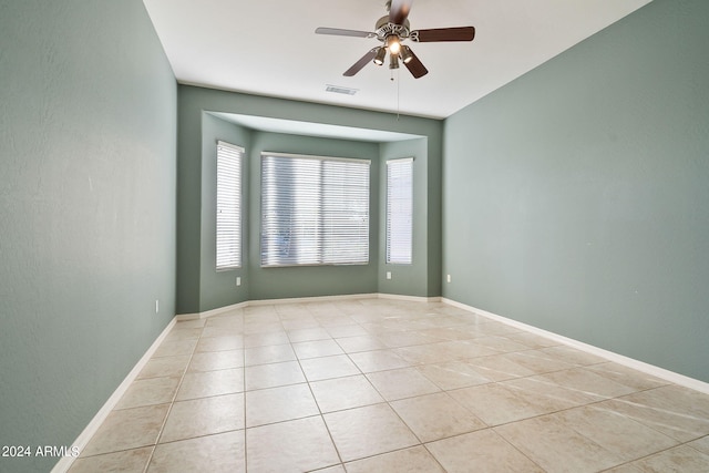 spare room with ceiling fan and light tile patterned flooring