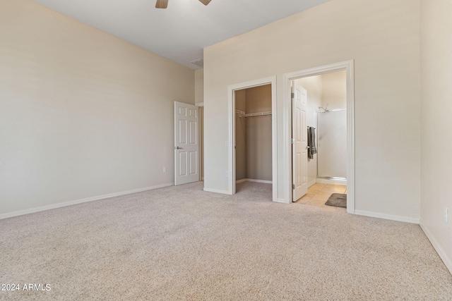 unfurnished bedroom featuring baseboards, ceiling fan, ensuite bathroom, carpet flooring, and a closet