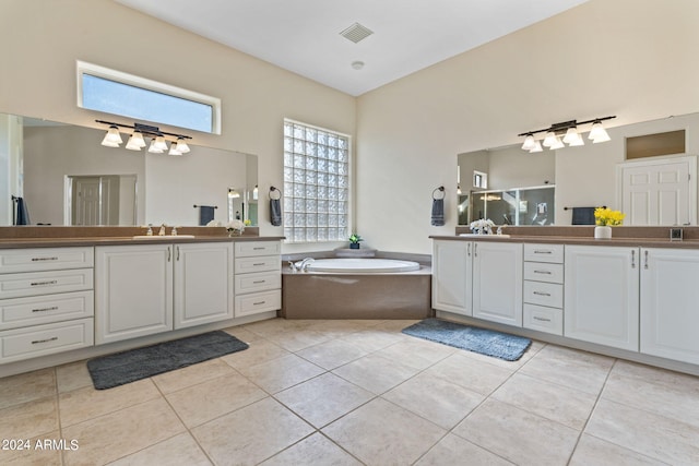 full bathroom with a garden tub, two vanities, a sink, visible vents, and tile patterned floors