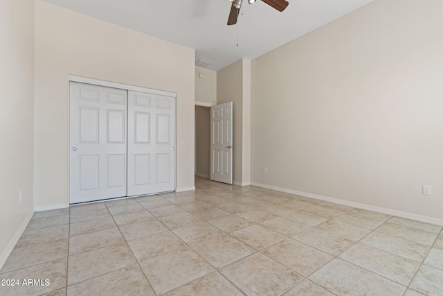 unfurnished bedroom with a closet, ceiling fan, baseboards, and light tile patterned floors