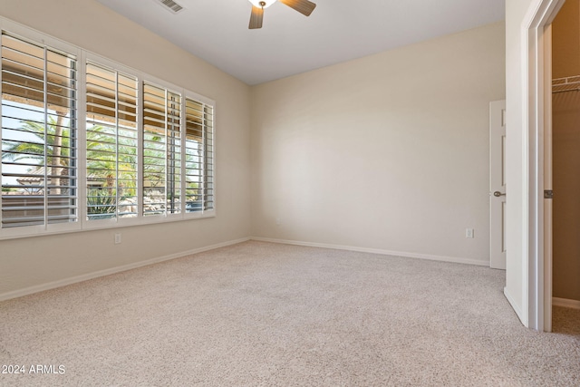 empty room with a ceiling fan, carpet floors, and baseboards