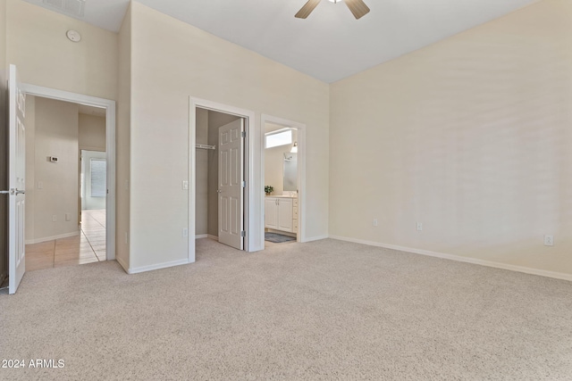 unfurnished bedroom featuring baseboards, a spacious closet, and light colored carpet