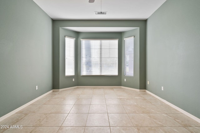 tiled spare room with ceiling fan and a healthy amount of sunlight