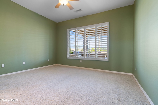 carpeted spare room featuring ceiling fan