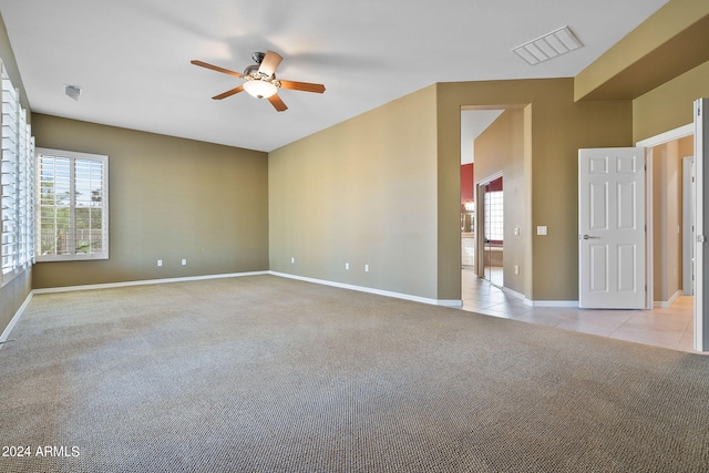 spare room featuring light colored carpet and ceiling fan