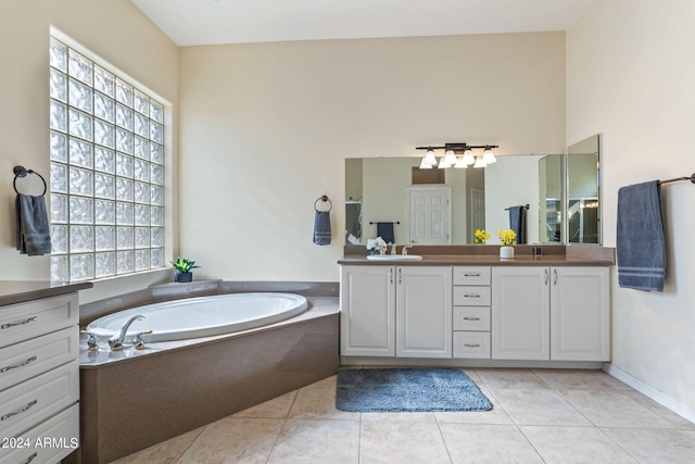 full bath featuring double vanity, tile patterned flooring, a sink, and a bath