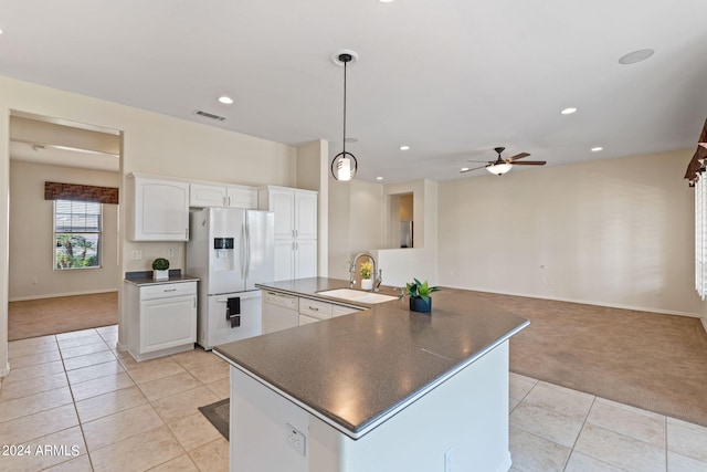 kitchen with dark countertops, white appliances, light colored carpet, and a sink