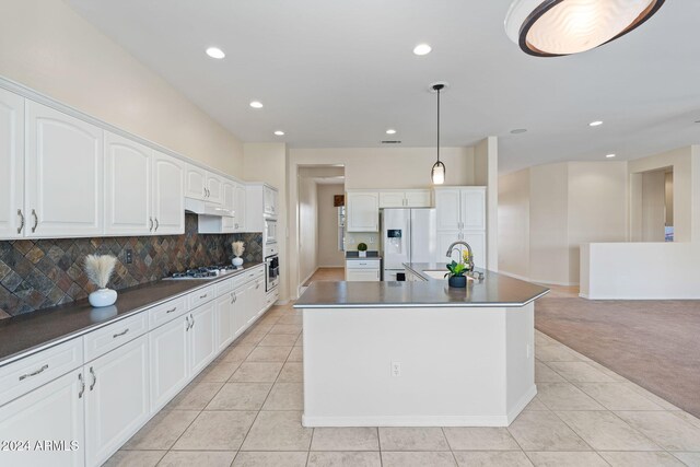 kitchen with light colored carpet, under cabinet range hood, a sink, white cabinets, and white fridge with ice dispenser