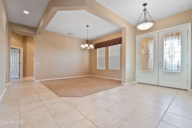 carpeted foyer entrance featuring a notable chandelier