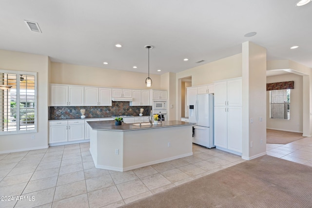 kitchen featuring tasteful backsplash, dark countertops, white appliances, and white cabinetry