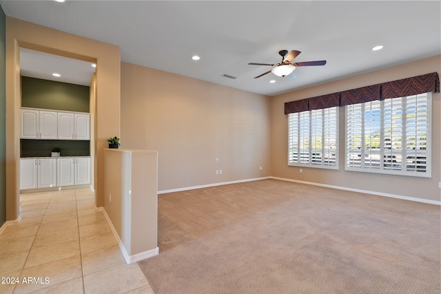 spare room featuring light colored carpet and ceiling fan