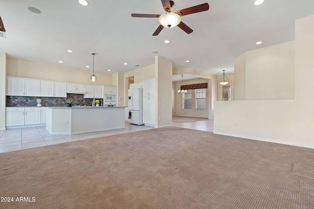 unfurnished living room featuring light carpet, light tile patterned flooring, and recessed lighting