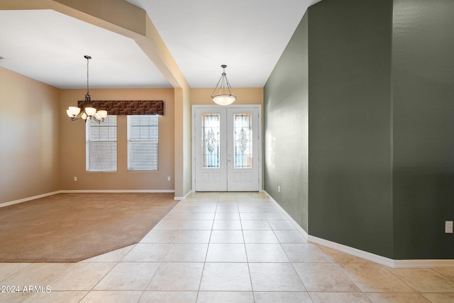 foyer entrance featuring light colored carpet and a notable chandelier