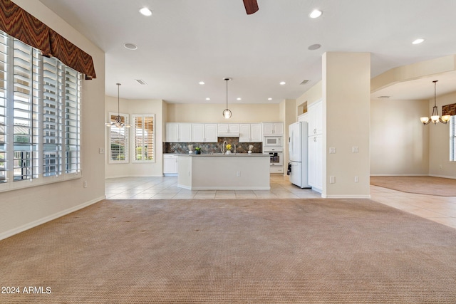 kitchen with white appliances, light carpet, and ceiling fan with notable chandelier