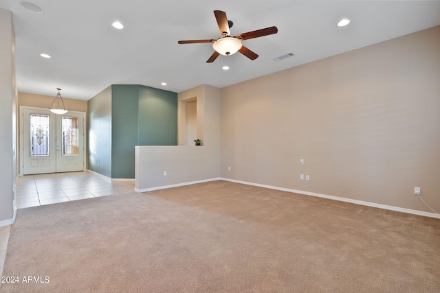 spare room with light colored carpet and ceiling fan