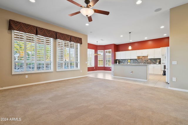 unfurnished living room with ceiling fan and light carpet