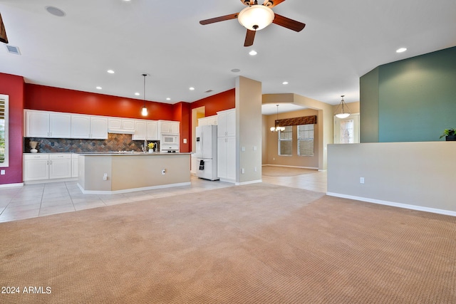 kitchen featuring ceiling fan with notable chandelier, white appliances, pendant lighting, decorative backsplash, and white cabinetry