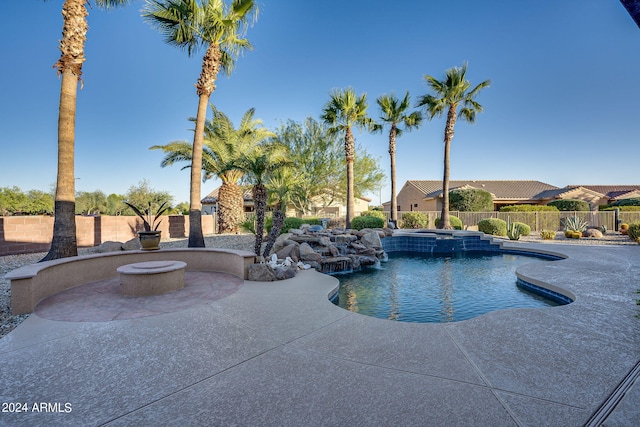 view of pool with a fire pit, a patio area, a fenced backyard, and a pool with connected hot tub