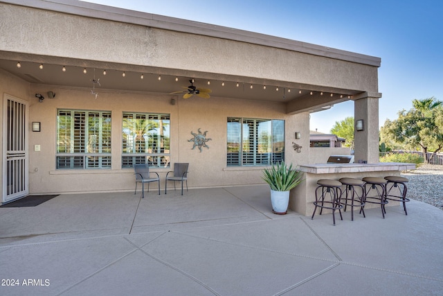 view of patio / terrace featuring outdoor dry bar, fence, a ceiling fan, and a grill