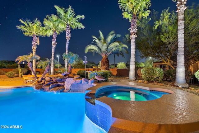 pool at twilight with an in ground hot tub