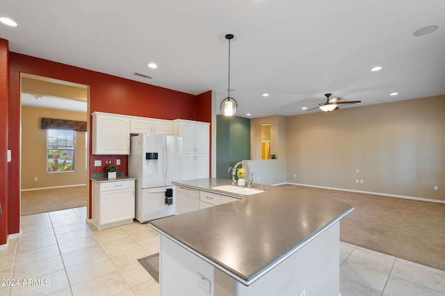 kitchen with white appliances, light colored carpet, sink, ceiling fan, and white cabinets