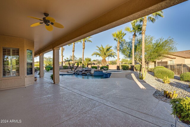 view of patio / terrace with a fenced in pool, an in ground hot tub, ceiling fan, and fence