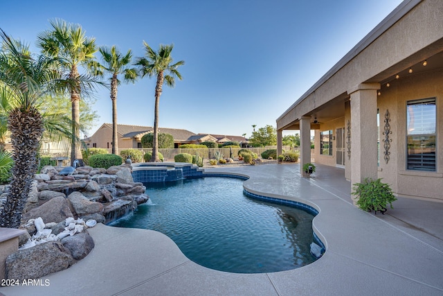 view of swimming pool with pool water feature, a patio area, and an in ground hot tub