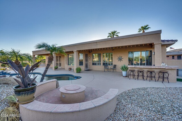 view of patio / terrace with a bar, ceiling fan, and grilling area