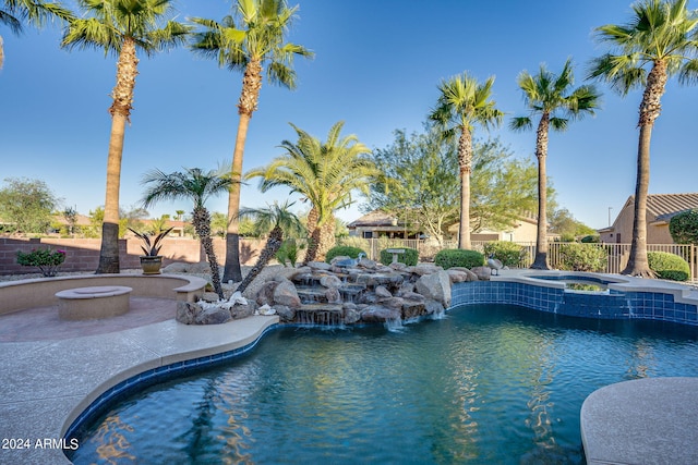 view of pool featuring a fire pit, an in ground hot tub, pool water feature, and a patio