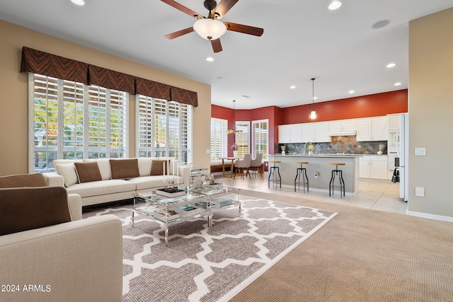 tiled living room with plenty of natural light and ceiling fan