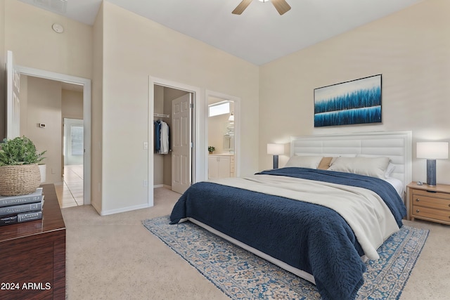 bedroom with baseboards, a walk in closet, a ceiling fan, and ensuite bathroom