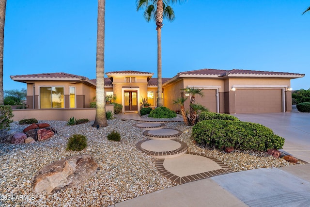 mediterranean / spanish-style home featuring a garage, concrete driveway, and stucco siding